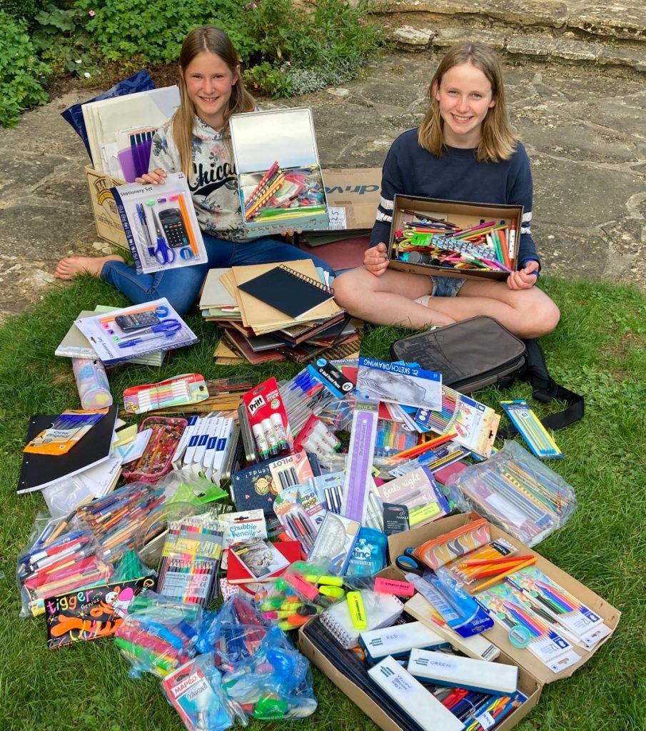 Two girls surrounded by sationery items