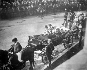 A group of people riding on the back of a horse drawn carriage