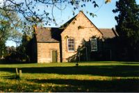 A large brick building with grass in front of a house