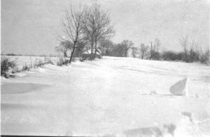 A person riding a snowboard down a snow covered field