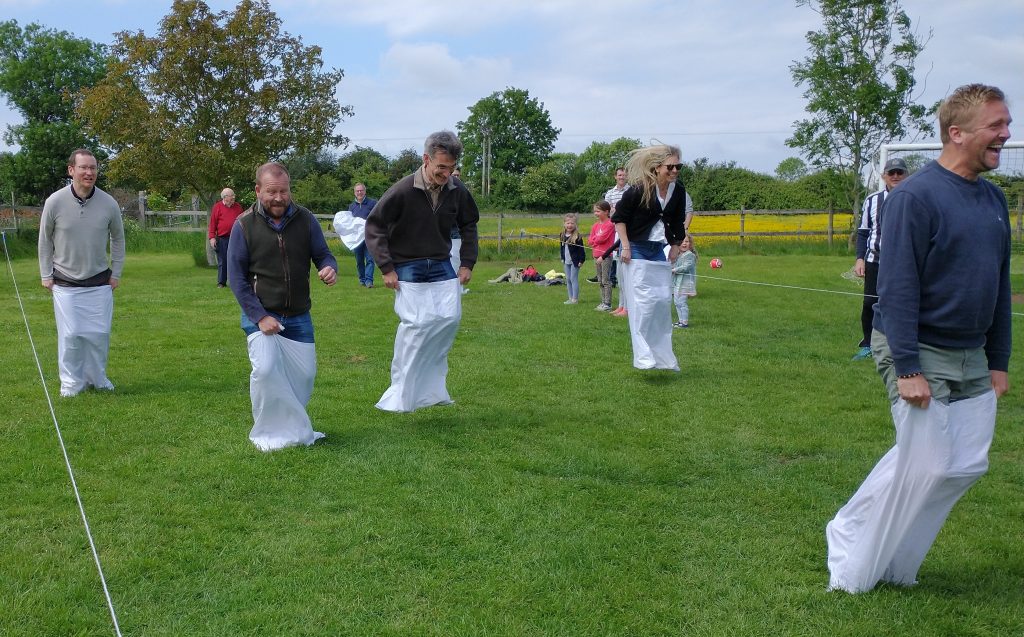 A group of people standing on top of a grass covered field