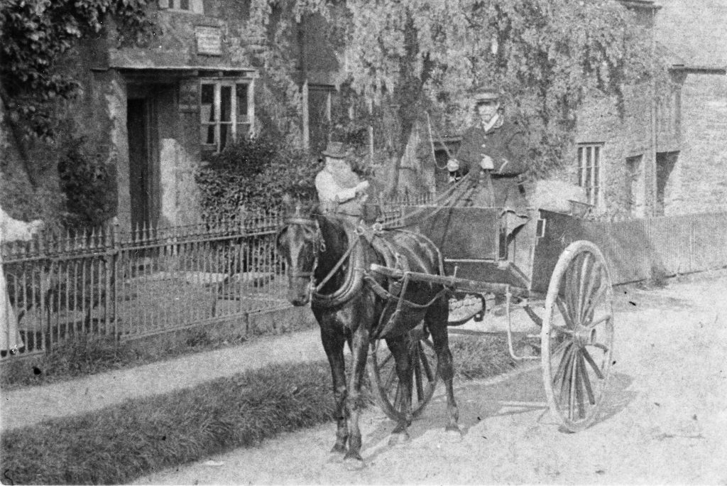 A person riding a horse drawn carriage