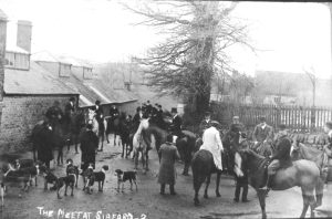 A group of people standing next to a horse