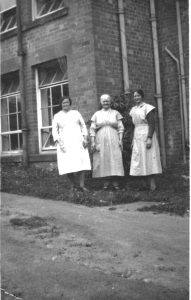 A group of people standing in front of a brick building
