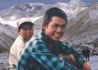 A man sitting on top of a snow covered mountain