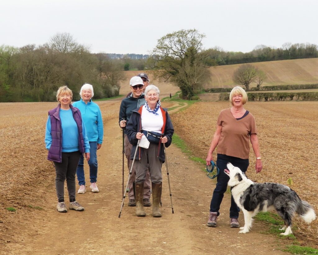 A group of people standing next to a dog
